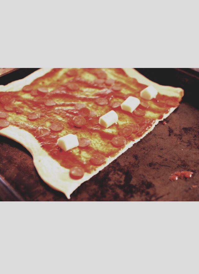 Place about 4-5 pieces of cut up string cheese across the dough like this.