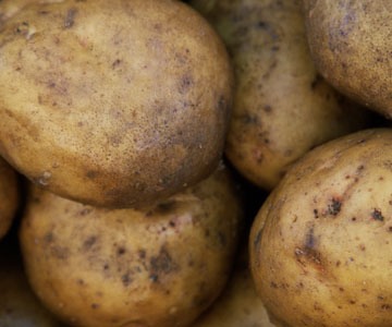 Preheat oven to 400 degrees and place potatoes directly on the oven rack. Bake for 50 minutes or until the skins are sharp. Remove potatoes from oven and let stand 10 minutes. Set oven to broil. Slice each potato in half lengthways and use a spoon to scoop out the inside, leaving 1/4 intact.
