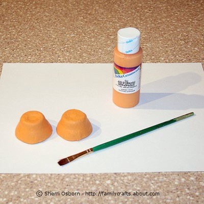 To create the fish body, paint the bottom sides of both egg carton cups. I used a bright orange paint, but you can use whatever color you like. Let the paint dry.