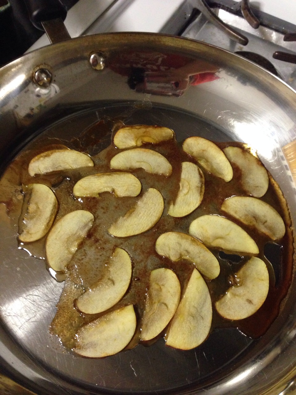 Mix the sugar and cinnamon together 
Add a few table spoons of water until you get a thick dark syrup
Caramelize the slices of apple with the syrup. 
Make sure each slice fully touches the surface of the pan.
Try to keep the slices in tact.
