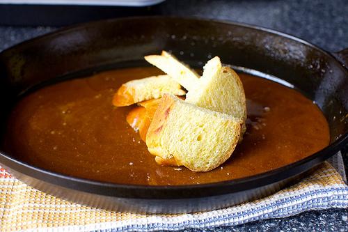 Once chilled, arrange the bread slices. Place the heel of the bread in the center and do what you can to fan the slices around it, overlapping each slightly and knowing with complete confidence that even if your dish doesn’t resemble a blooming rose, nobody will care at all.