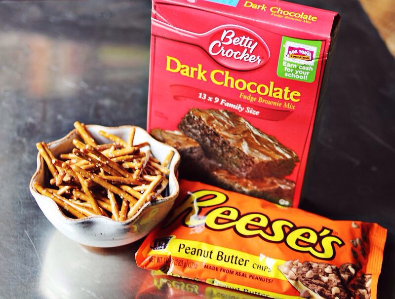 Use any brownie box mix you like plus the ingredients it calls for. I usually reduce the amount of water called for by 1/2 to 1 tablespoon. Less water tends to make brownies more dense and less cake-like. I love a dense, gooey brownie. Then add a bag of peanut butter chips and 2 handfuls of pretzels