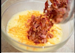 In medium bowl, beat eggs and milk. Stir in bacon and cheese.