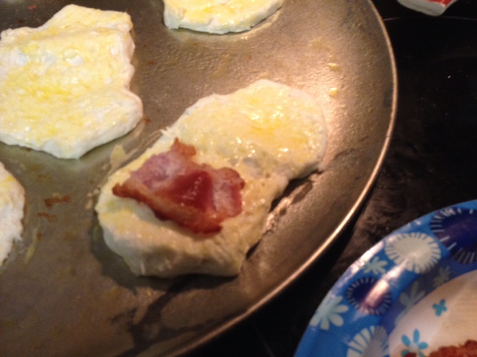 Place a bacon slice on the biscuit. 