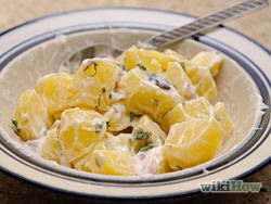 8) In a large bowl combine 1 cup sour cream, mayonnaise, black olives, green onions and cheese, add potatoes and mix thoroughly.