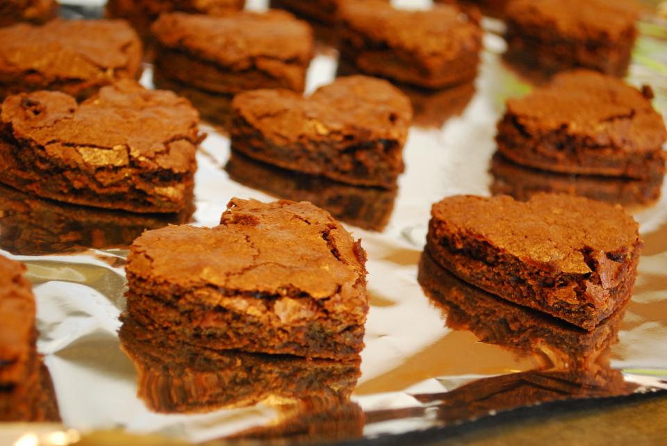 1. Take a small heart-shaped cookie cutter and cut heart shapes out of your pan of brownies. Place the heart shaped brownies on a foil-lined baking pan.