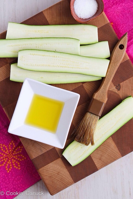 -> Slice a strip lengthwise from the zucchini to expose the inside of the vegetable. 
-> Cut the 2 ends from the zucchini to make straight edges. 
-> Cut the zucchini lengthwise into 1/2-inch strips.
-> Brush both sides of the zucchini with olive oil. Season with salt and pepper. 