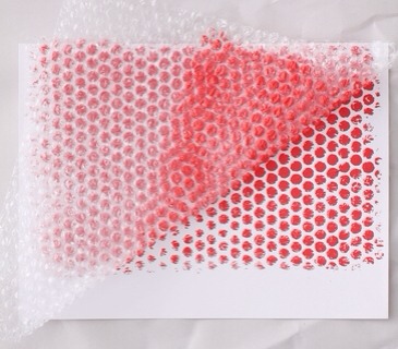 How To: Floral Pop Cont.
Place a sheet of paper on a clean piece of newspaper. Picking up the bubble wrap by the edges, lay it on top of the plain paper. Press gently and then slowly peel away.
Set paper aside to dry.
