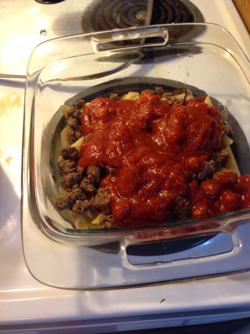 Add half of your meat and half of the sauce you plan to use for your pasta. (You can sprinkle more cheese atop the sauce if you'd like). 