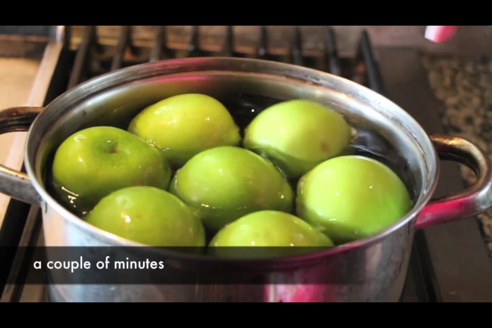Place apples in hot water for a few minutes to remove wax.
