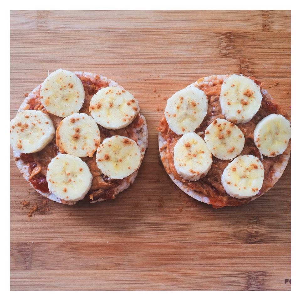 Brown rice cakes topped with organic peanut butter, fruit spread, bananas and cinnamon