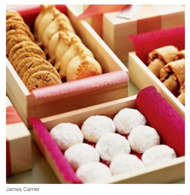 Package cookies in small wooden boxes lined with colorful tissue paper.
