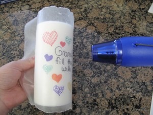 Kids wanna make mommy something nice? Get some wax paper and have the kids draw something nice. Wrap it around the candle and use a blow dryer.
For more information, http://www.thehappierhomemaker.com/2011/07/designing-your-own-candles.html