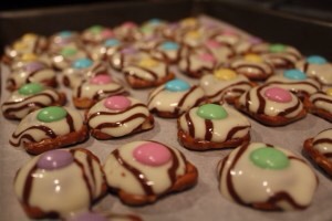5. Top each hug/pretzel with an M&M, with the M face down.