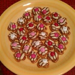 Preheat oven to 350 degrees F (175 degrees C).
Place pretzels on baking sheets. Unwrap candy kisses and place one in the center of each pretzel.
Place in preheated oven 1 to 2 minutes, until kisses melt. Remove from oven and place one candy-coated chocolate in the center of each pretzel.