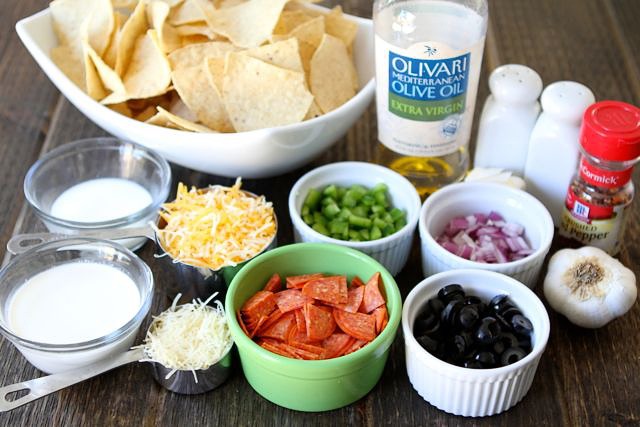 To make the Pizza Nachos, you will need: butter, olive oil, garlic, heavy cream, milk, salt, pepper, red pepper flakes, Parmesan cheese, tortilla chips, onion, pepperoni, black olives, green pepper, and Colby Jack cheese.