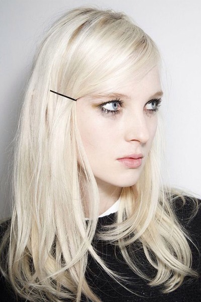 Hold a deep side part in place with a bobby pin placed just above the ear. Let hair fall lightly across the forehead to fake bangs. 

