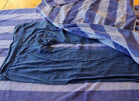 Then, get another dry towel and put the piece of clothing out on the dry towel.