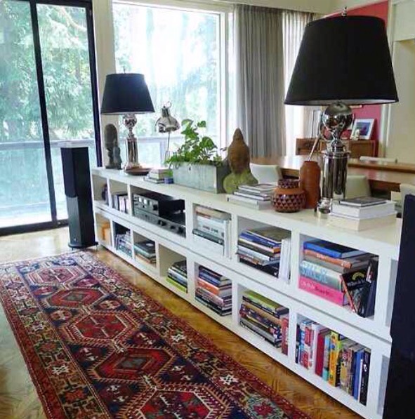 Stack Lack bookcases behind a couch to visually divide your space while also providing tons of storage!!