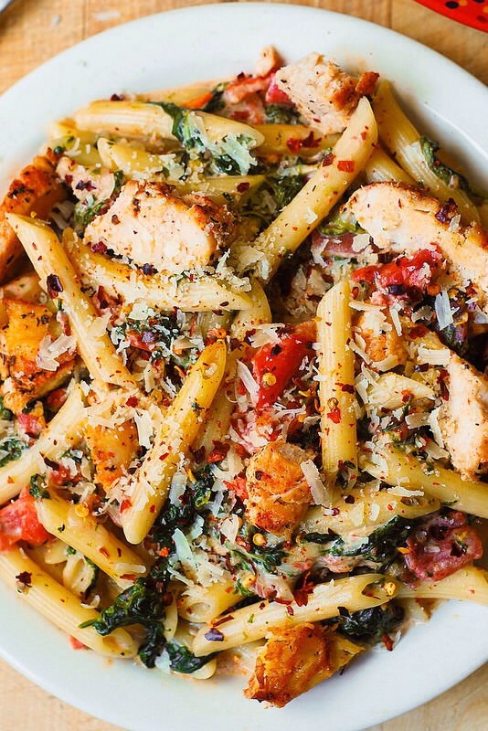 Chicken and bacon pasta with spinach and tomatoes in garlic cream sauce
