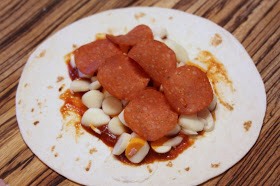 Step-by-Step:
To your tortilla, start by adding some pizza sauce, cut up (or shredded) cheese, and the pepperoni.  Don't go all the way to the edges.