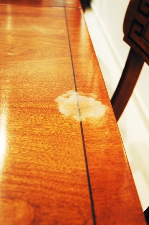 22. Removing white stains on wood

You're going to take two white linen clothes and put them over the spot. You want there to be a good layer of cloth. Then you'll spray it with water to dampen it. You'll get your iron out and set it on medium/steam and iron over the cloth for about 15 seconds.