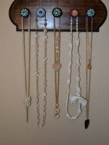 A vintage wooden platform with a couple old dresser knobs are perfect for holding your necklaces and add decoration to your room!