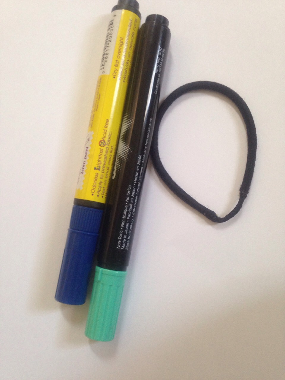 You need some long, straight markers (I suggest using thick markers) and a hair tie