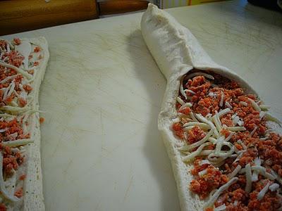 Spoon half of the pepperoni mixture down center of each loaf.  Gather up edges over filling, pinching firmly to seal.  