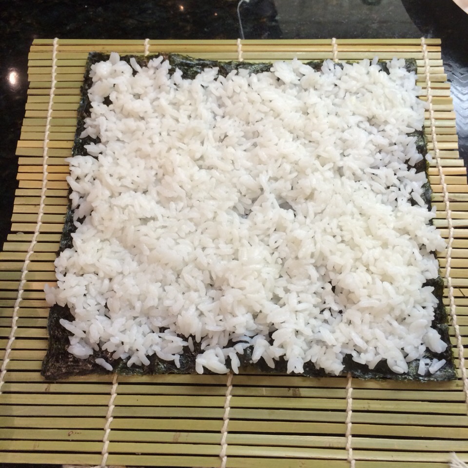 Spread the rice throughout the whole seaweed paper.