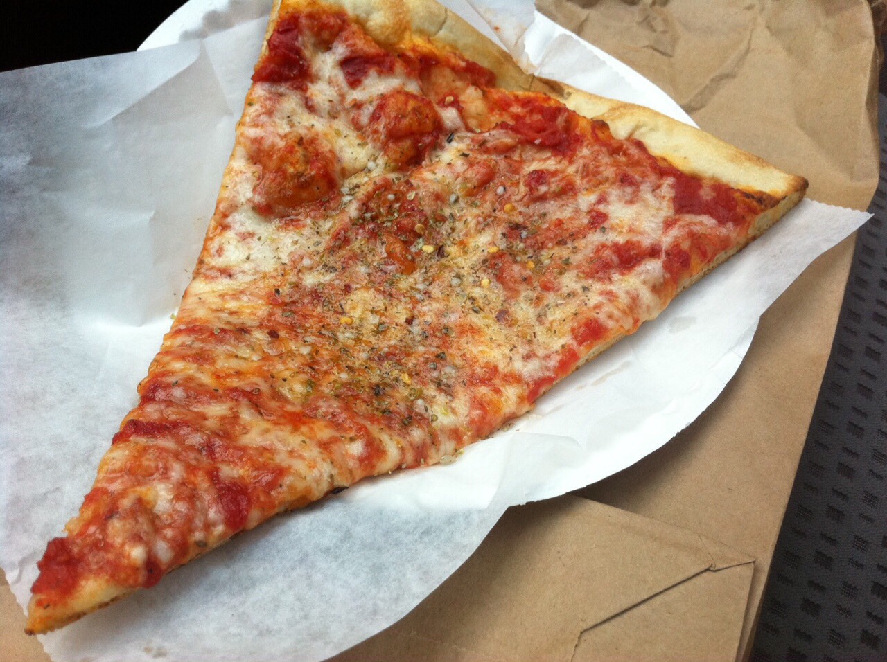 
6. New York-Style Press dough into an oiled 15-inch pizza pan. Drizzle with olive oil, then top with 1/2 cup tomato sauce and 2 cups shredded mozzarella. Bake, then garnish with pecorino, dried oregano and olive oil.