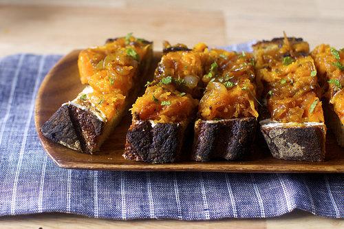 Spread cheese on toasts, heap with the squash-onion mixture, sprinkle with coarse salt and garnish with mint.