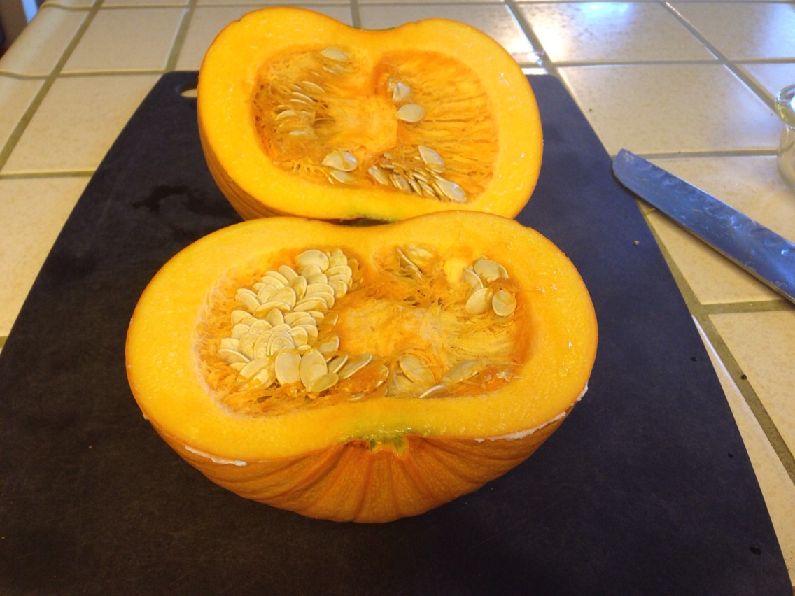 Wash the pumpkin, take off stem and cut in half.