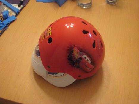 Marked with Sharpie, cut with heavy duty scissors. I ended up with enough left over to do the two ear covers.

The helmet has enough space between the hard platic shell and the hard foam that the cut frisbee could fit into it.