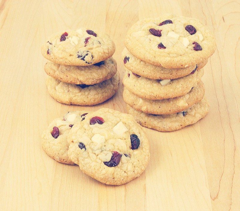 In a large bowl, cream together the butter, brown sugar, and white sugar until smooth. Beat in the egg and brandy. Combine the flour and baking soda; stir into the sugar mixture. Mix in the white chocolate chips and cranberries. Drop by heaping spoonfuls onto prepared cookie sheets.
