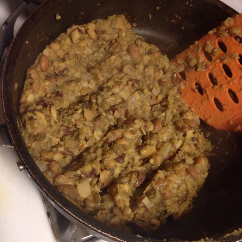 Add the beans to the onions and remove it from the heat. Then, mash half the beans.
π« Add some of the water you boiled the beans in when it starts to get too dry.
