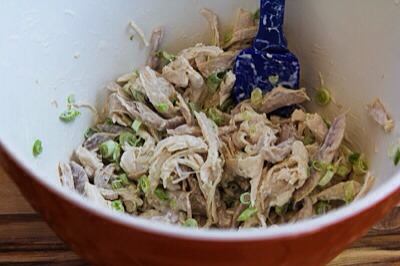 Put the chicken in a bowl large enough to hold all the ingredients, add the sliced green onions and dressing and mix well, so all the chicken is coated with dressing.