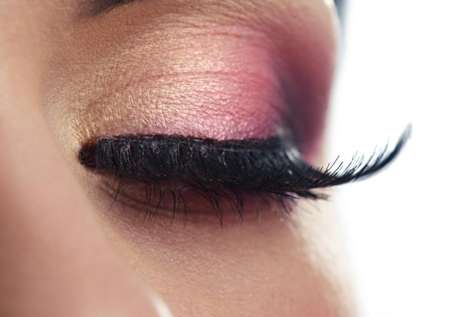 First, take your falsies and loosen them by gently flexing the eyelash band, then curl your natural lashes to make sure your falsies line up with your actual lash line. Apply glue on your falsies using a Q-tip. Using tweezers place your falsies as close to your lash line as possible. Let your lashes