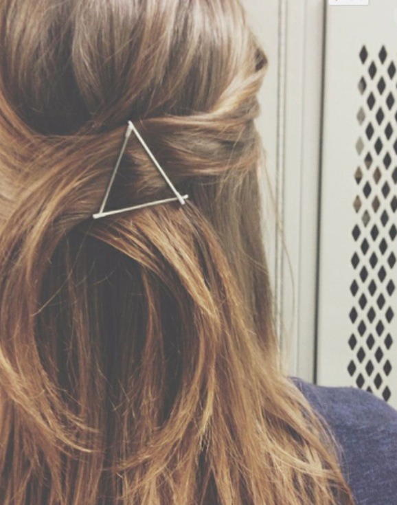 Use bobby pins to fake an elaborate clip. Position three in a triangular formation to create a half-up style. 

