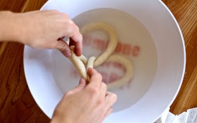 Combine the warm water and baking soda in a wide bowl. Form the dough into pretzel shapes, then dip in the baking soda water

That's what really makes it into a pretzel. It gives it that chewy brown crust. 