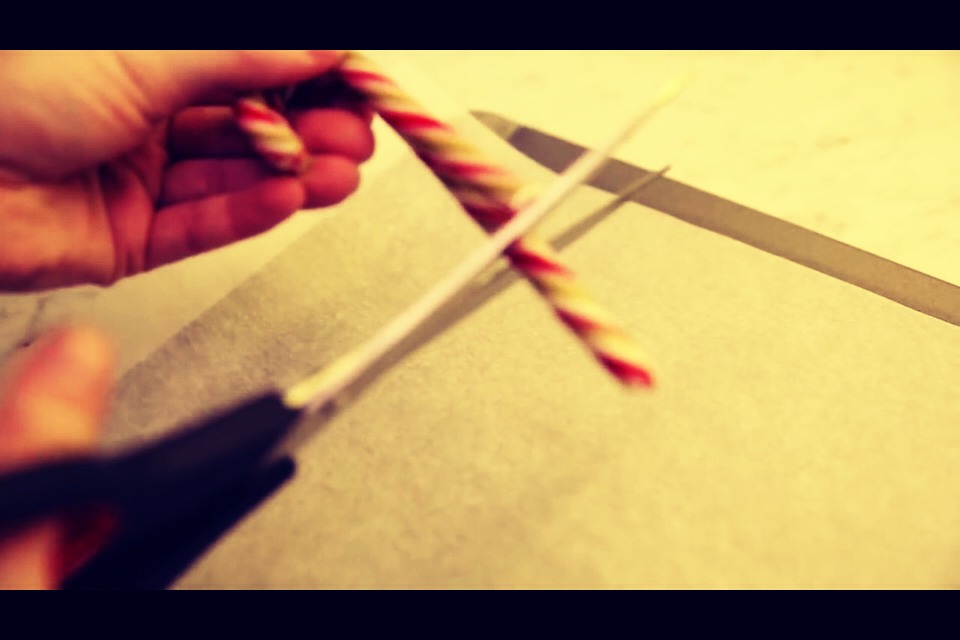 Place parchment paper (NOT wax paper) on a cookie sheet and cut candy canes to smaller size to represent small candy canes.