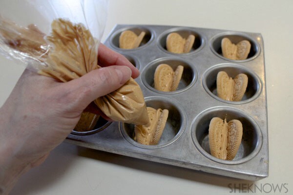 • Melt the peanut butter candy melts in a microwave (three, 30-second intervals, stirring between each heating) and pour into a piping bag or plastic zip-closed bag.
• Cut off the tip and pipe the melted peanut butter candy between the cut Oreo wafers.