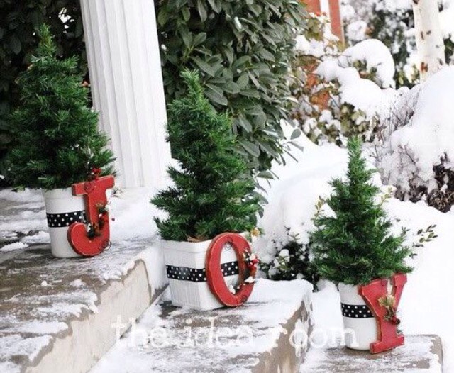 Get white pots, put pine trees inside of them and put letters spelling out a word on the pots.