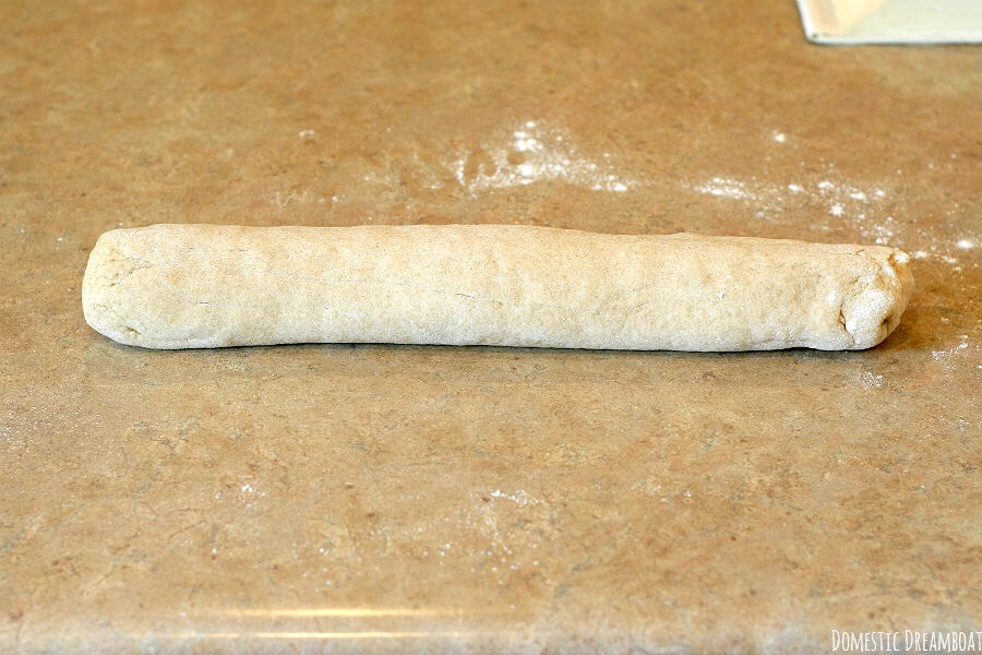 Grease large cookie sheet with shortening or spray with cooking spray; sprinkle with cornmeal. Gently push fist into dough to deflate; divide in half. On lightly floured surface, roll each half into 15 x 8-inch rectangle. Roll dough up tightly, beginning at 15-inch side, to form a loaf.