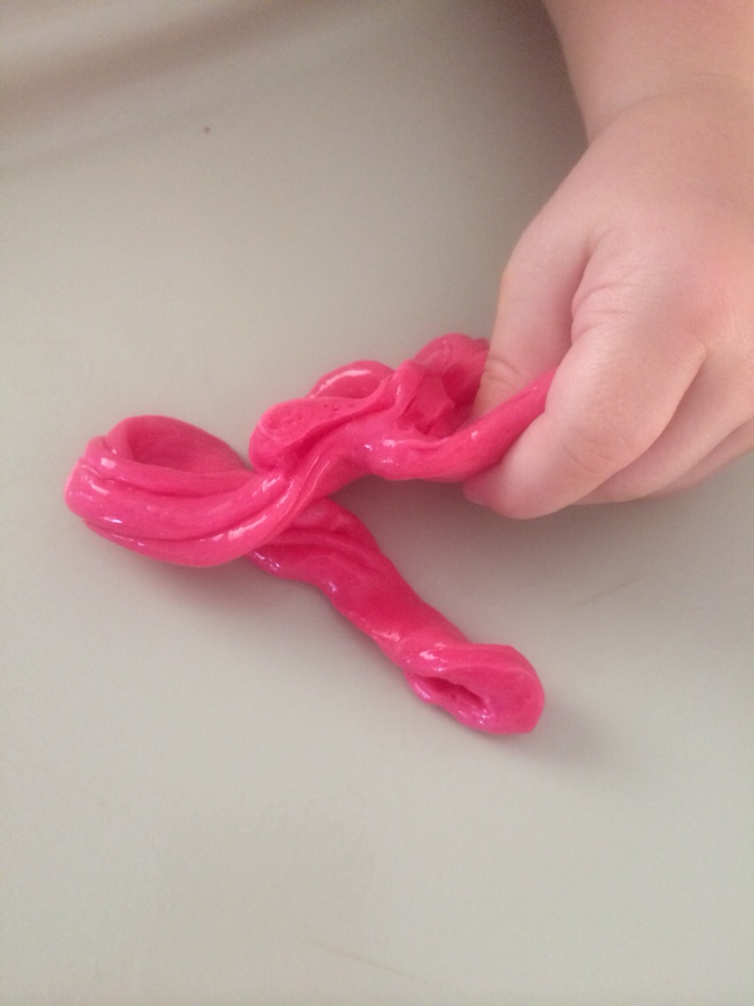 Stir a couple of drops of food coloring into the glue mixture.
Add a spoonful of the borax solution to the glue mixture. Stir (if in a plastic cup) or squish (if in a baggie).
Have fun with your snot!