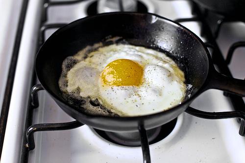 Reheat skillet over medium-high heat. Add the butter and swirl it to coat the pan. Crack one egg into the skillet, season with salt and pepper and reduce heat to medium. I like to cover the skillet with a small lid at this point, as it seems to help the egg cook faster and more evenly. 