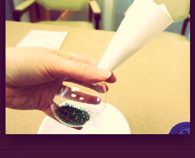 Step two- add the glitter to the pledge floor shine inside of the ornament. Do it without a mess by making a funnel out of a piece of paper.(: