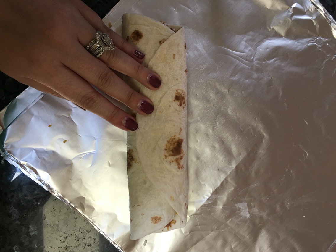 Then, roll your burrito up and wrap with your foil. Repeat until there's no more filling. Put your burritos in the freezer in ziplock gallon size bags (5-6 fit in each bag).
Eat whenever & enjoy!!!