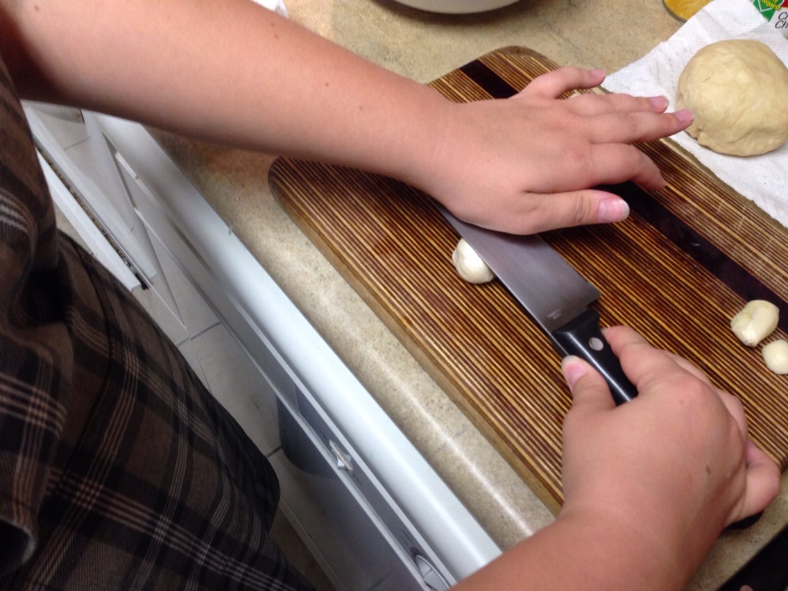 To quickly peel your garlic, place the blade of your knife over the clove as shown and smash your hand down. This will crack the clove in half, making it easier to peel! Finely chop your garlic and stir it evenly into the chicken pan.