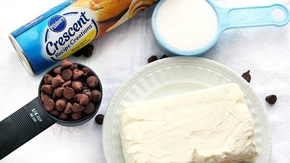 Are you ready to surprise your family with a flaky, buttery pastry oozing with sweet cheese and chocolate goodness? First, gather your ingredients: crescent dough, cream cheese, sugar, chocolate chips and vanilla extract. That’s it!